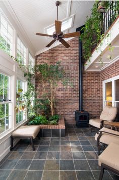 an indoor living room with brick walls and ceiling fan