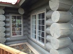 a log cabin with windows and logs on the outside