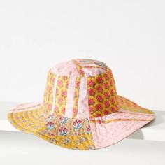 a yellow and pink hat sitting on top of a white shelf