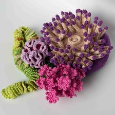 three crocheted flowers sitting on top of each other