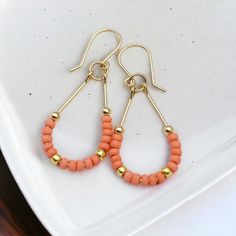 Make a statement with Lane - Gold & Coral! These 14k Gold filled teardrop hoop earrings featuring Peach coral seed beads will guarantee you some serious style points. Perfect for a fun summer night out! Approximately 1.75” long Made with 14k Gold Filled wire Glass Miyuki Seed Beads Polished to a high shine Handmade in Montana Sent in a ribboned gift box with polishing cloth Teardrop Hoop Earrings, Wired Glass, Open Hoop Earrings, Summer Night, Delicate Earrings, Stunning Earrings, Fun Summer, Precious Jewelry, Jewelry Packaging