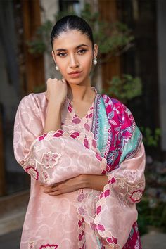 A blush pink cotton net kurta is adorned with scalloped embroidery along the neckline and sleeves and leaf motifs in a mulberry hue. A painterly printed mulberry hued medium silk dupatta is paired with a matching rawsilk trousers. Pink Naqshi Salwar Kameez For Festivals, Spring Pink Lawn Suit With Straight Kurta, Pink Naqshi Kurta For Festivals, Summer Pink Palazzo Set With Sheer Dupatta, Elegant Pink Palazzo Set For Summer, Elegant Pink Palazzo Set For Spring, Pink Raw Silk Palazzo Set With Chikankari Embroidery, Pink Raw Silk Palazzo Set With Straight Kurta, Pink Salwar Kameez With Naqshi In Traditional Drape