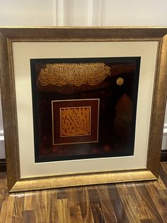 an ornate framed art work in gold and black