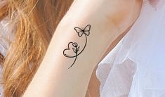 a woman's arm with a butterfly tattoo on the left side of her arm