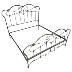 a metal bed frame with an iron headboard and foot board on the bottom end