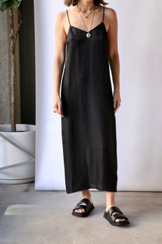 The product description for Tibi The Slip Dress in Black highlights its versatile qualities. Crafted from a drapey lightweight twill weave in two essential colorways, Black and Brown, this slip dress serves as the grounding element in any wardrobe, allowing for creativity and experimentation while maintaining a polished and professional look. With the right accessories, it can effortlessly transition from a casual afternoon outing to an elegant evening affair. For a more relaxed style, pair it w Black Highlights, Twill Weave, Wrap Sweater, Dress Jewelry, Professional Look, Relaxed Style, Fashion Company, Formal Event, Tank Top Shirt