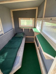 the inside of a small camper with bunk beds and green carpeting on the floor