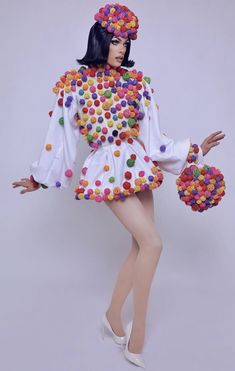 a woman dressed in a costume made out of buttons and plastic balls is posing for the camera