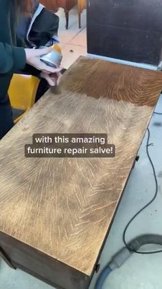 a woman is working on a table that has been refinished with furniture repair