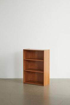 an empty wooden book shelf against a white wall with no one in it or someone standing on the floor