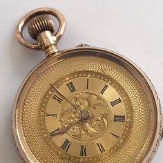 ANTIQUE Ladies 14k Gold Fob/Pocket Watch. c.1900. Beautifully floral engraved 14k gold case having  vacant cartouche to rear of case. Guilded inner back. Unusual guilded dial having decorative engine turning to outside of dial and engraved scroll work to centre of dial with black roman numerals. Guilded hands.  Swiss movement. Bow wound and pin hand set. Watch dimensions - 33mm diameter. Height inc bow 48mm. This watch is sold with a 12 month guarantee from MBHI certificated watchmakers, established 1947. All watches will be serviced before shipping hence the 2-3 week dispatch. Please note - Watches are not waterproof unless otherwise stated and it is recommended not to wear them near water (i.e. washing hands, washing up, shower, swimming etc). Antique Gold Watches With Chronometer, Victorian Yellow Gold Pocket Watch With Chronometer, Victorian Gold Watch With Chronometer, Victorian Style Gold Watch With Chronometer, Engraved Yellow Gold Pocket Watch With Round Dial, Victorian Yellow Gold Formal Watches, Heirloom Engraved Yellow Gold Pocket Watch, Elegant Engraved Yellow Gold Pocket Watch, Vintage Hallmarked Yellow Gold Pocket Watch