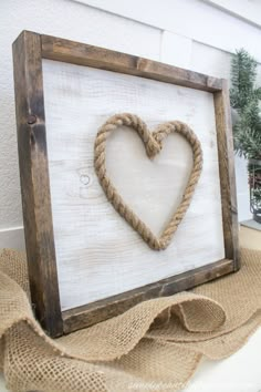 a wooden frame with a rope heart on it