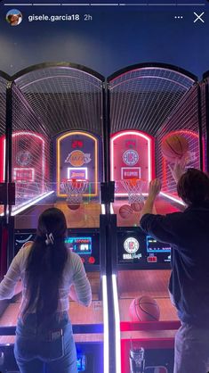 two people playing basketball in an interactive pinball game with neon lights on the walls