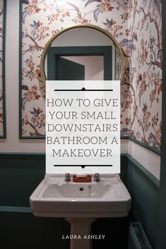 a bathroom sink sitting under a mirror next to a wallpapered wall with words on it