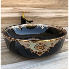 a black and gold bowl sink sitting on top of a wooden counter