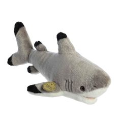 a stuffed shark is laying down on the white ground with it's mouth open