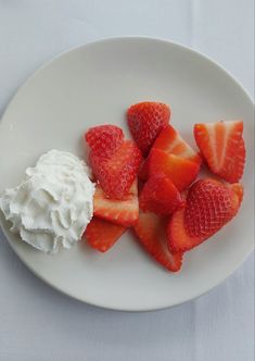 strawberries and whipped cream on a white plate