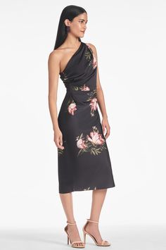 The Carmen Dress - Noir Blossom is sure to make a lasting impression. Featuring a mid-length silhouette, one shoulder design, and a timeless floral print, the dress exudes elegance and sophistication. Constructed of a luxurious satin crepe, you're sure to feel your best for any occasion.The belt is not included. Details:Model is 5'10" wearing size 242" LongSide ZipperPrinted Satin Crepe100% PolyesterImportedStyle #F232D24-004 Knee-length Floral Dress For Evening, Elegant Sleeveless Silk Floral Dress, Elegant Silk Floral Dress For Garden Party, Feminine One-shoulder Dress For Date Night, One Shoulder Feminine Dress For Date Night, Floral Print One Shoulder Spring Dress, Spring Floral Print One-shoulder Dress, Spring Evening One Shoulder Dress With Asymmetrical Neckline, Spring One Shoulder Dress With Floral Print