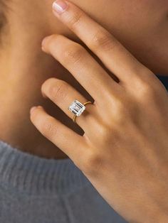 a woman's hand with a diamond ring on her finger