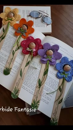 paper flowers are placed on top of an open book with the pages cut out to look like children's books