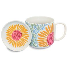 two mugs with flower designs on them, one has a saucer and the other is