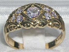 *This ring is made from 375 9K Yellow Gold with Natural TanzanitesA beautiful Victorian Style Tanzanite Ring set with a centre 4.5mm (0.18" inches) and six 2.25mm (0.09" inches)  Tanzanites set in a gorgeous 9ct Gold setting. PLEASE MAKE SURE YOU STATE THE FINGER SIZE YOU REQUIRE WITH YOUR PAYMENT.Completely made from Solid English 9K Gold Hallmarked by the London Assay Office which confirms the rings authenticity. The Hallmark includes the 375 marking for 9K Gold. This is a delightful piece to Pink And Gold Rings, Heirloom Amethyst Ring With Diamond In Gold, Heirloom Gold Amethyst Ring With Diamond, Gold Amethyst Ring With Rose Cut Diamonds For Anniversary, Heirloom Gold Amethyst Ring For Weddings, Anniversary Amethyst Ring With Rose Cut Diamonds, Heirloom Amethyst Ring With Rose Cut Diamonds For Wedding, Gold Amethyst Ring With Brilliant Cut For Wedding, Formal Gold Amethyst Ring With Rose Cut Diamonds