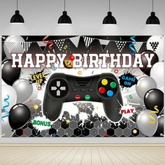 a video game controller in front of a happy birthday banner with balloons and confetti