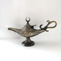 an ornate metal teapot with handles on a white background