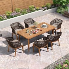 an outdoor dining table with chairs and plates on it in the middle of a patio