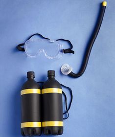 two black water bottles with goggles on them next to a pair of eyeglasses