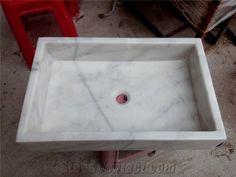 a white square sink sitting on top of a floor