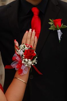 a close up of a person wearing a suit and tie with flowers on his arm