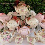 a table topped with lots of pink and white tea set sitting next to each other