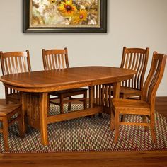 a dining room table and chairs with a potted plant on the floor next to it