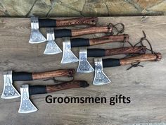 five different types of axes on a wooden table with the words, groomsmen gifts