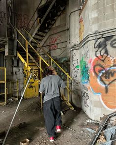 a person walking up some stairs near graffiti