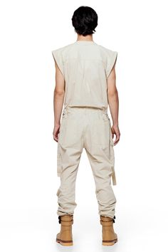 Jonny Cota takes on the summer suit with this season's Sleeveless Canvas Jumpsuit, crafted from soft baby canvas with cargo patch pockets and gun metal hardware detailing throughout. — Cargo patch pockets— Gun metal snaps— Zip closure at center middle— 100% baby canvas suedeSIZE + FIT— Loose, relaxed fit— Adjustable d-ring belt at waist— Model is 6’0 and wearing a size L CARE— Dry clean recommended Utility Style Sleeveless Jumpsuits And Rompers With Pockets, Sleeveless Cotton Utility Jumpsuits And Rompers, Utility Cotton Jumpsuits And Rompers For Summer, Summer Utility Cotton Jumpsuits And Rompers, Cotton Utility Jumpsuits And Rompers For Summer, Cargo Style Overall Jumpsuit For Summer, Utility Cotton Khaki Jumpsuits And Rompers, Utility Cotton Jumpsuits And Rompers With Patch Pockets, Utility Cotton Jumpsuits And Rompers With Cargo Pockets