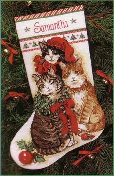 a cross stitch christmas stocking with two cats