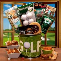 the golf gift basket is on display in a green bucket with white balls and snacks