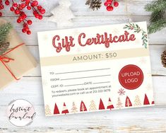 a gift certificate with christmas decorations and presents around it on a white wooden table, surrounded by pine cones