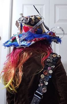 a woman with red hair wearing a hat made out of buttons and other things on her head