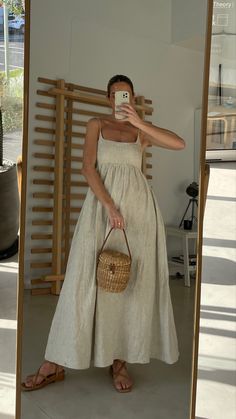 Women wearing full length linen dress. The dress is a neutral colour with thin straps, a fitted bust area and a flowy skirt Modern Bohemian Fashion, Style Inspiration Summer 2024, Spring Italy Outfits, Rainy Day Summer Outfits, Honeymoon Fits, Greece Fits, Linen Summer Outfits, August Outfits, Linen Outfits