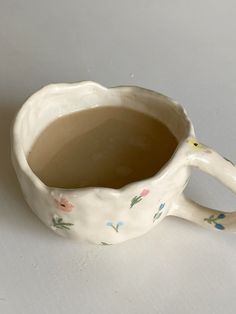 a white cup with flowers painted on it