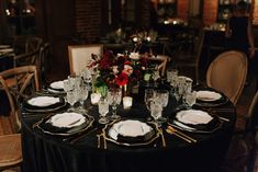 a table set with plates, silverware and flowers on it for a formal dinner