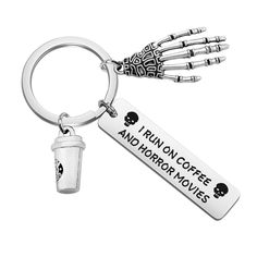 a keychain with a coffee cup and skeleton hands on it that says run on coffee and horror movies