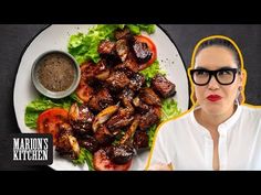 a woman with glasses is next to a plate of meat and lettuce on it