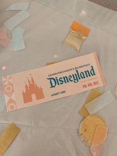 the disneyland ticket is laying on top of some confetti and other things that are scattered around it