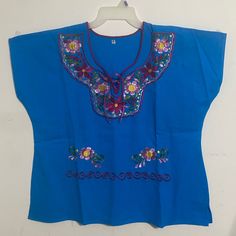 Artisanal Mexican Blouse Color Turquoise Whit Beautiful Embroidered Pink And Burgundy Flowers Sisexl .27” Long From Shoulder To Bottom And 26.6” Chest. New No Tags. Blue V-neck Top With Floral Embroidery, Light Blue Embroidered V-neck Top, Blue Floral Embroidery Beach Tops, Blue Floral Embroidery Top For Vacation, Blue Short Sleeve Folk Blouse, Light Blue Floral Embroidery Tops For Vacation, Blue Folk Style Short Sleeve Blouse, Blue Folk Style Summer Blouse, Blue Folk Style Tops For Beach