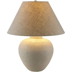 a white ceramic table lamp with a beige shade