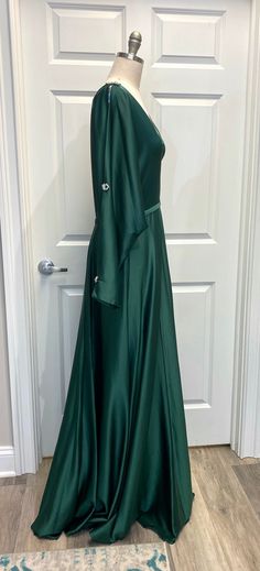 Rhinestone Embellished Split Sleeve Satin Gown. Color: Forest Green Please note: This listing is for our sample dress only. This dress has been tried on in our Newtown, CT shop but has never been worn to an event or altered in any way. Measurements:Bust: 42"Waist: 34"Hip: 45"Dress size 16 To ensure accurate shipping cost please contact us at 203-426-2598 or email Salesatpersnickety@icloud.com for accurate quote. Floor-length Embellished Satin Ball Gown, Embellished Satin Floor-length Ball Gown, Embellished Floor-length Satin Ball Gown, Elegant Green Ball Gown For Pageant, Elegant Gown For Pageant And Prom Season, Floor-length Evening Dress With Fitted Bodice For Pageants, Pageant Floor-length Dress With Sweep Train, Floor-length Pageant Dress With Sweep Train, Elegant Green Pageant Dress